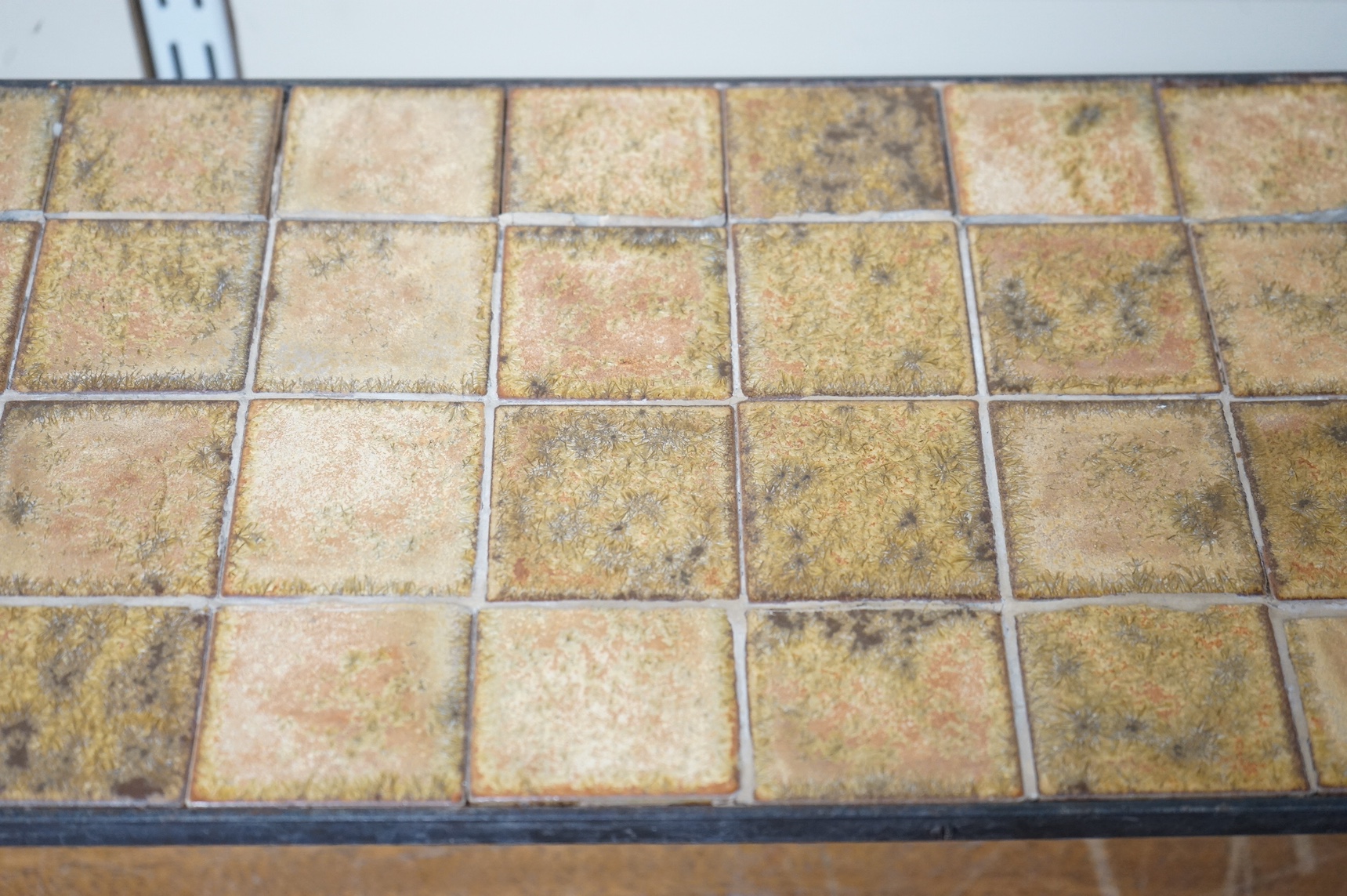 Manner of Roger Capron (French), an Iron and ceramic tile top table, 76cm wide. Condition - fair